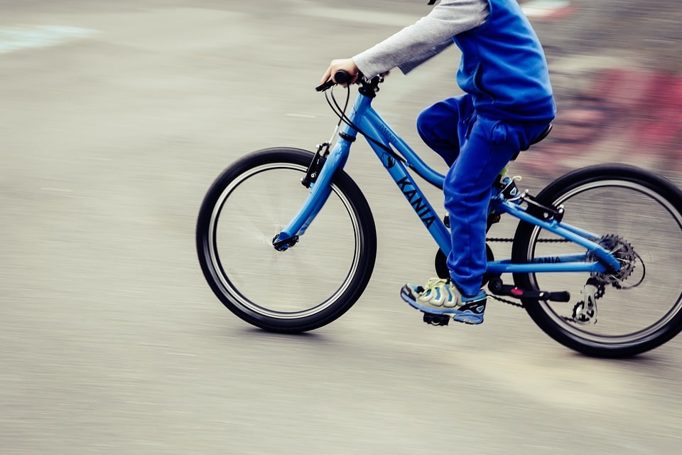 child riding a blue bike