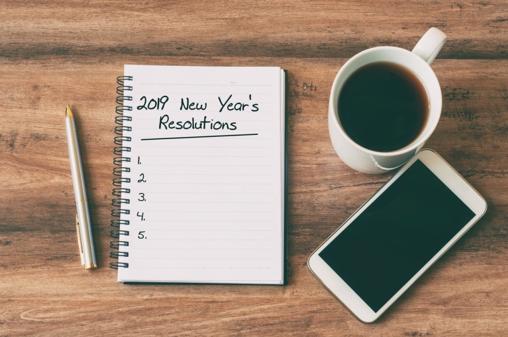 new Years Resolution checklist next to coffee and phone