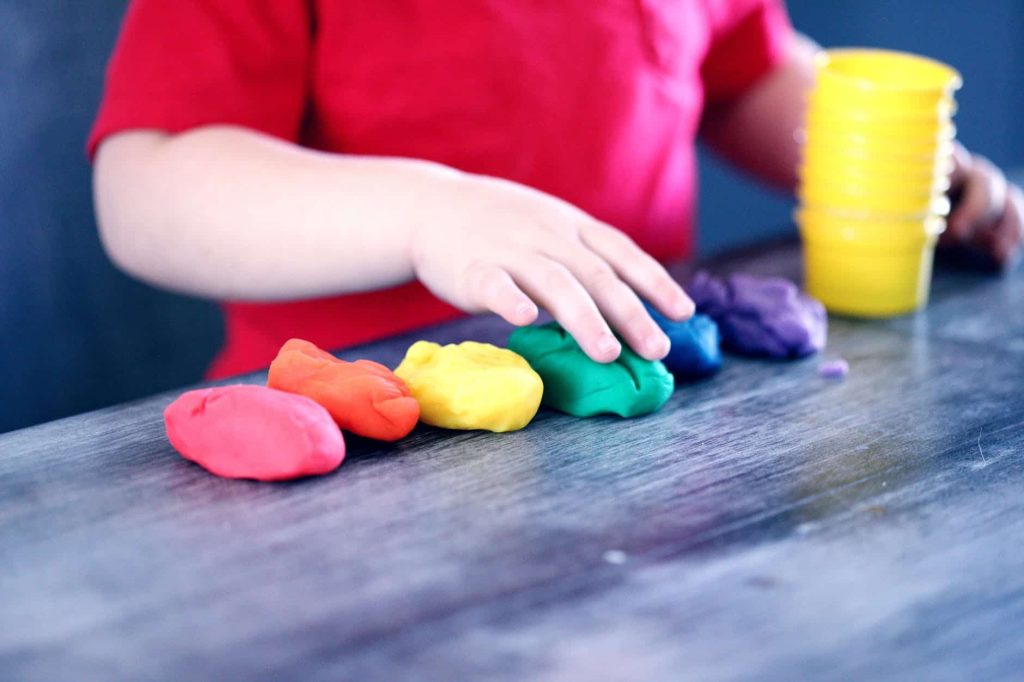 child playing with colorful playdough