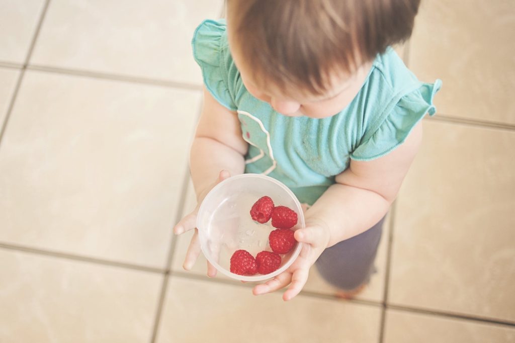 toddler with raspberries