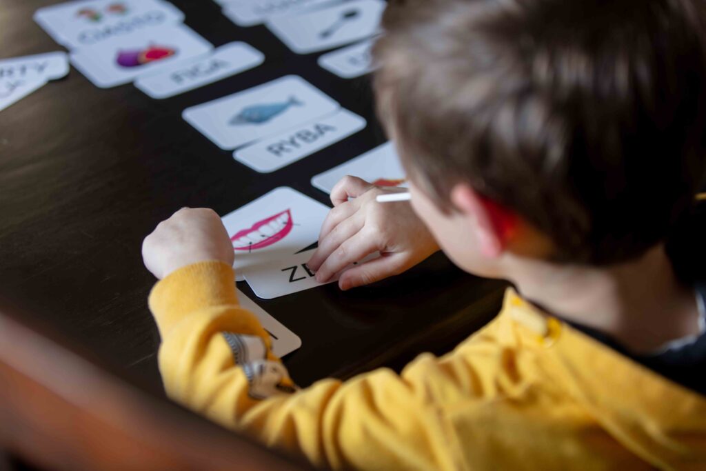 child sitting at table looking at learning cards